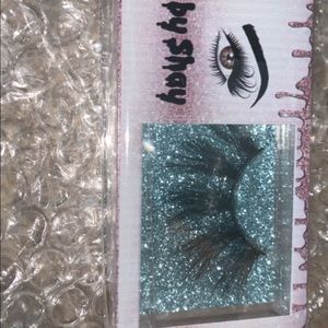 Lashes by Shay come with tweezers and a brush .